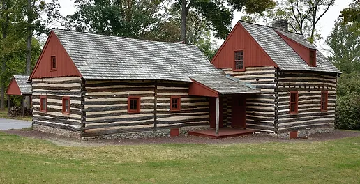 A log cabin with red trim and white walls.